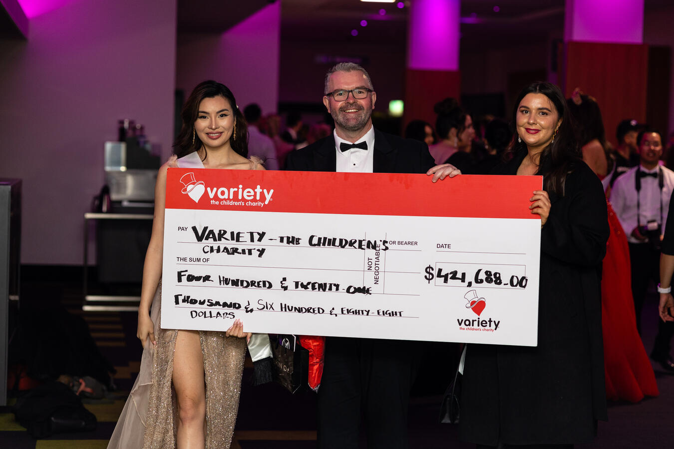 Lenny Cheng Leonor Cheng holding a large cheque with representatives at a Variety Children’s Charity event; total raised: $424,688.