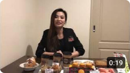 Lenny Cheng presenting a café concept in a classroom video during private school at age sixteen, seated with sample products.